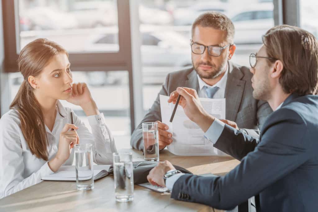 group of business people with contracts having meeting at modern office